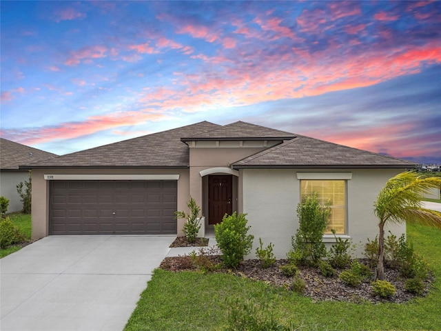 view of front of home with a shingled roof, an attached garage, a front lawn, stucco siding, and driveway