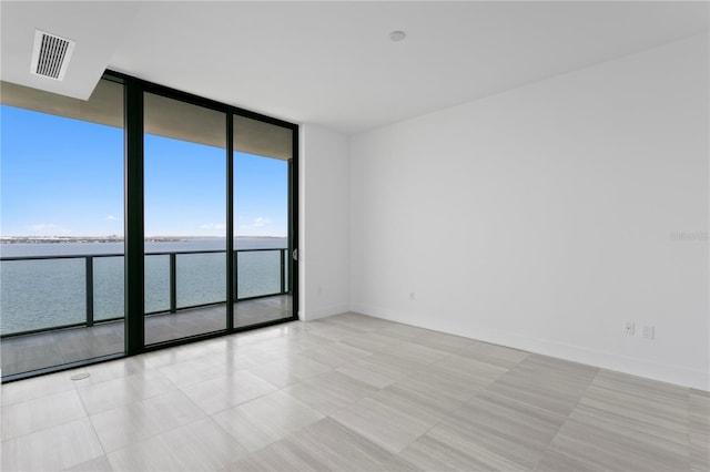 2912 W Santiago St Unit 1401, Tampa, FL 33629 - spare room with a wall of windows, visible vents, light tile patterned floors, baseboards, and a water view
