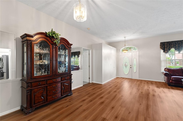 2803 Bent Leaf Dr, Valrico, FL 33594 - entrance foyer with wood finished floors, baseboards, a chandelier, and a textured ceiling