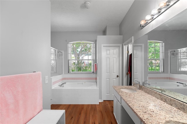 2803 Bent Leaf Dr, Valrico, FL 33594 - full bathroom featuring a bath, wood finished floors, a stall shower, vanity, and a textured ceiling