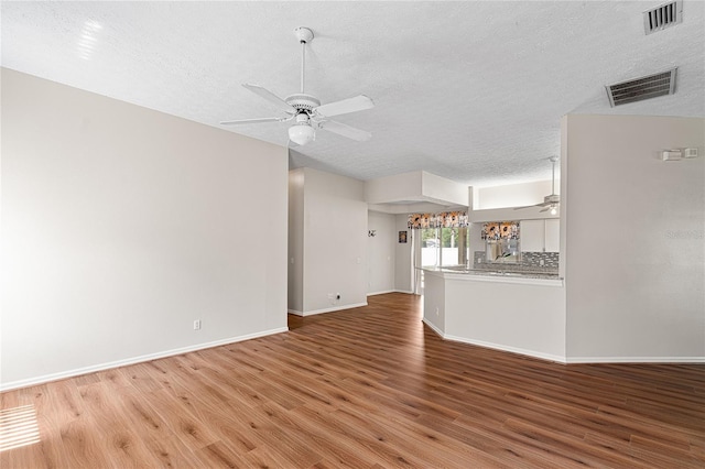 2803 Bent Leaf Dr, Valrico, FL 33594 - unfurnished living room featuring ceiling fan, a textured ceiling, light wood-style flooring, and baseboards