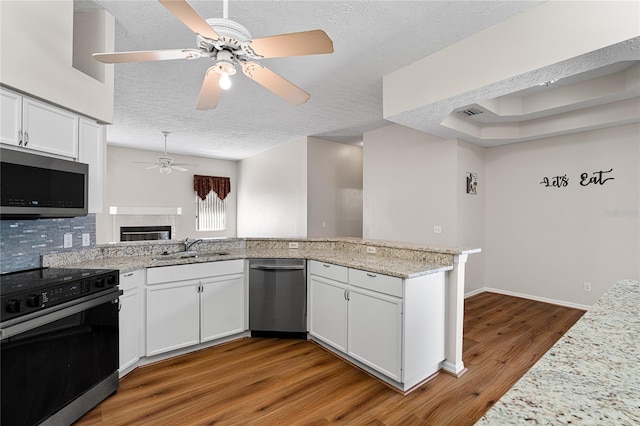 2803 Bent Leaf Dr, Valrico, FL 33594 - kitchen featuring stainless steel appliances, ceiling fan, a sink, a textured ceiling, and wood finished floors