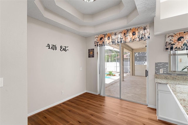 2803 Bent Leaf Dr, Valrico, FL 33594 - unfurnished dining area with light wood-type flooring, baseboards, and a raised ceiling