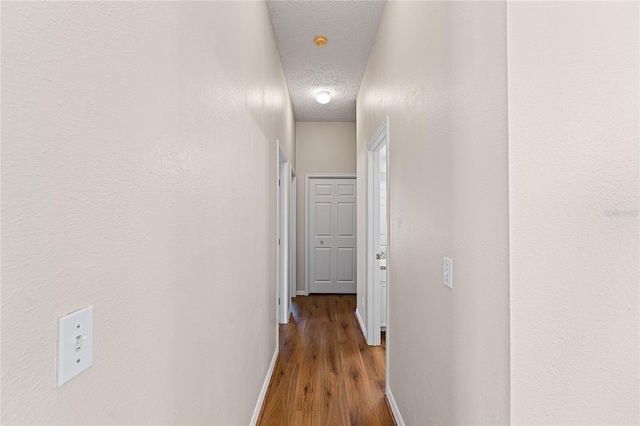2803 Bent Leaf Dr, Valrico, FL 33594 - hall featuring a textured ceiling, baseboards, and wood finished floors