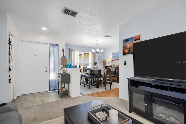1657 Glengarry Dr, Palm Harbor, FL 34684 - living room with visible vents, a textured ceiling, carpet, and a chandelier