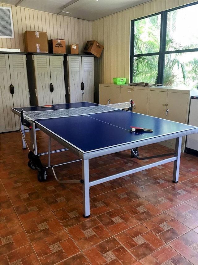 1657 Glengarry Dr, Palm Harbor, FL 34684 - game room featuring visible vents, brick floor, and wooden walls