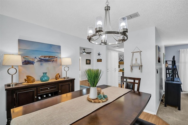 1657 Glengarry Dr, Palm Harbor, FL 34684 - dining room with baseboards, ceiling fan with notable chandelier, a textured ceiling, and visible vents