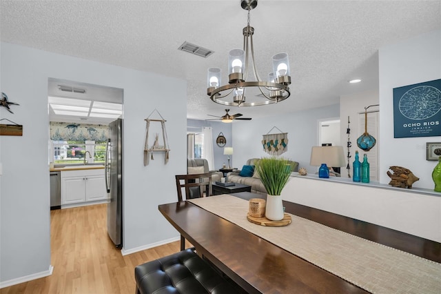 1657 Glengarry Dr, Palm Harbor, FL 34684 - dining room with baseboards, light wood-style flooring, a textured ceiling, and visible vents