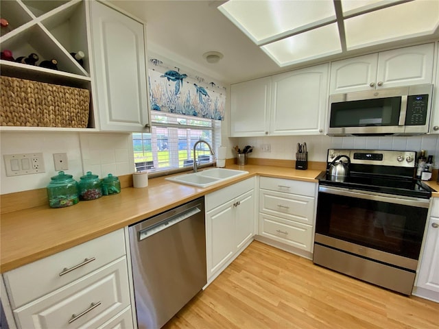 1657 Glengarry Dr, Palm Harbor, FL 34684 - kitchen featuring a sink, appliances with stainless steel finishes, open shelves, and backsplash