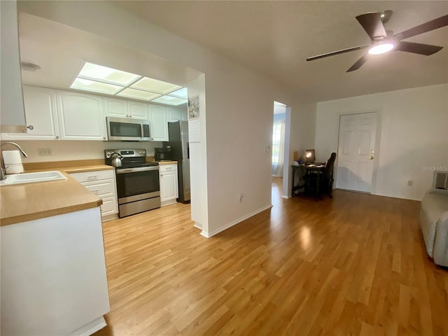 1657 Glengarry Dr, Palm Harbor, FL 34684 - kitchen with appliances with stainless steel finishes, open floor plan, light wood-type flooring, and light countertops