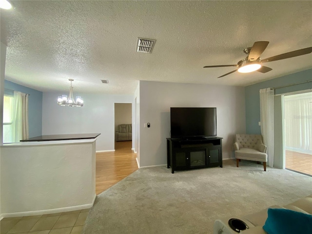 1657 Glengarry Dr, Palm Harbor, FL 34684 - living area featuring a chandelier, ceiling fan, light colored carpet, and a textured ceiling