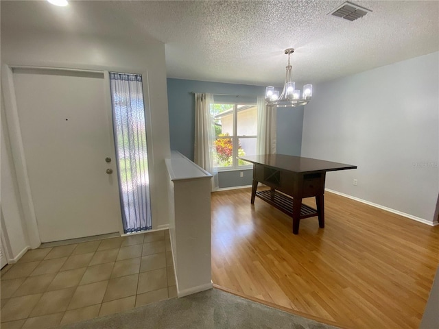 1657 Glengarry Dr, Palm Harbor, FL 34684 - entryway featuring a chandelier, a textured ceiling, and light wood-type flooring