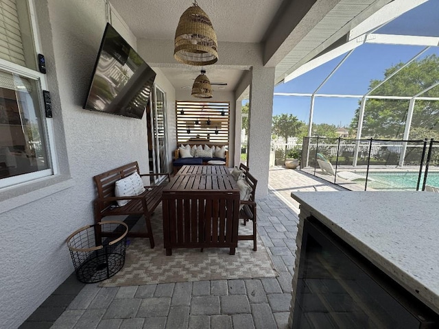 view of patio with ceiling fan, wine cooler, an outdoor living space, glass enclosure, and an outdoor pool