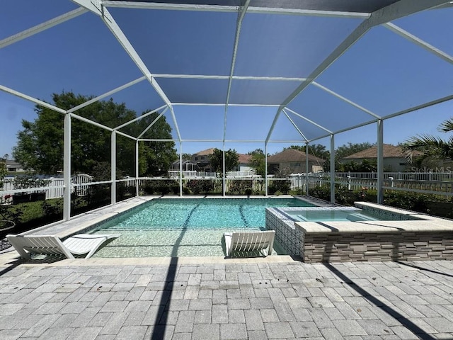 view of swimming pool with a patio area, fence, a pool with connected hot tub, and a lanai