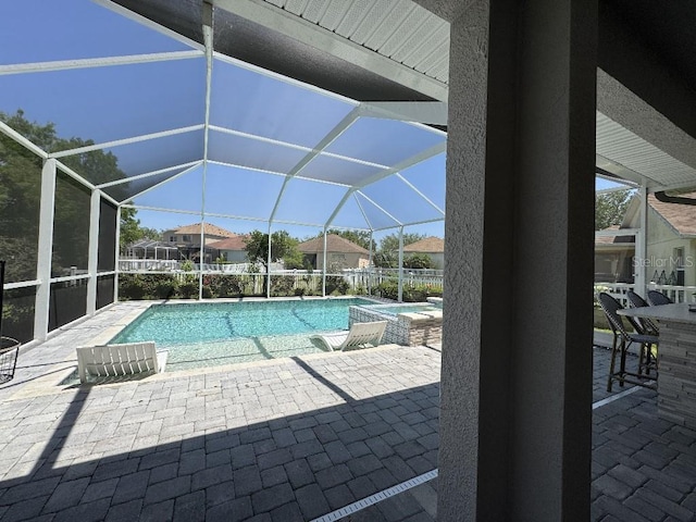 view of swimming pool with a patio, a pool with connected hot tub, and a lanai