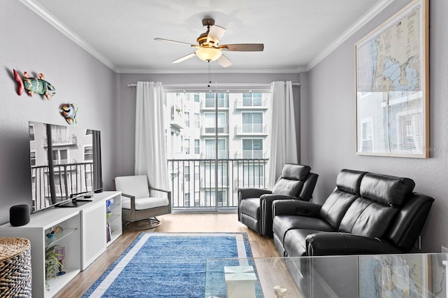 living area featuring light wood-type flooring, crown molding, and a ceiling fan