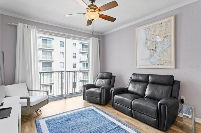living area with crown molding, wood finished floors, and a ceiling fan