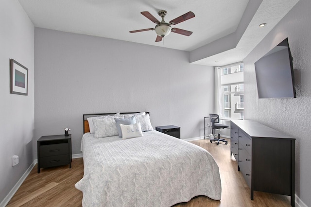 bedroom featuring ceiling fan, baseboards, and wood finished floors