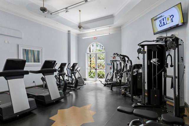 gym with a raised ceiling and crown molding