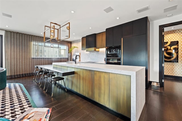 325 2nd St N, Saint Petersburg, FL 33701 - kitchen with a spacious island, visible vents, a notable chandelier, wallpapered walls, and dark wood-type flooring
