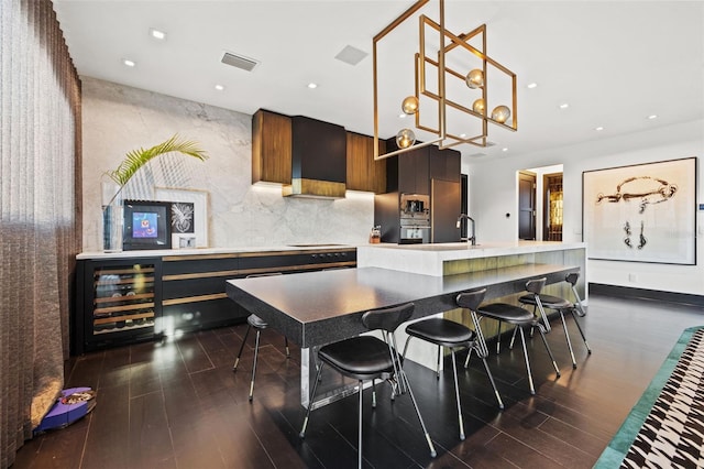 325 2nd St N, Saint Petersburg, FL 33701 - kitchen featuring dark wood finished floors, modern cabinets, light countertops, decorative light fixtures, and beverage cooler