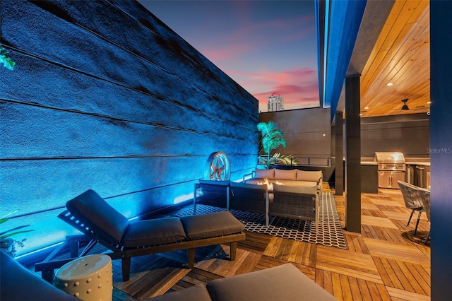 325 2nd St N, Saint Petersburg, FL 33701 - patio terrace at dusk with a wooden deck, an outdoor living space with a fire pit, and area for grilling