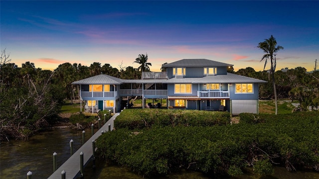 9048 Wharf Ave, Placida, FL 33946 - back of house at dusk featuring metal roof, a water view, and a balcony