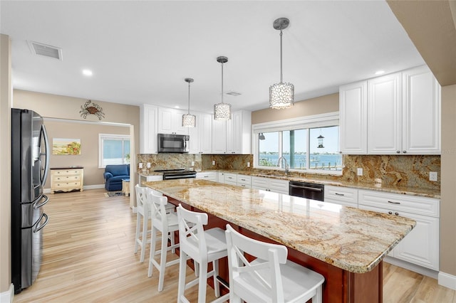 9048 Wharf Ave, Placida, FL 33946 - kitchen with visible vents, a healthy amount of sunlight, white cabinetry, and stainless steel appliances