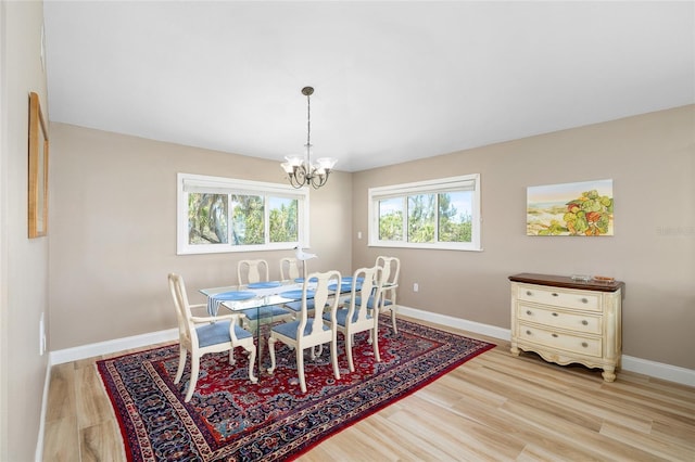 9048 Wharf Ave, Placida, FL 33946 - dining area with a chandelier, light wood-style flooring, and baseboards