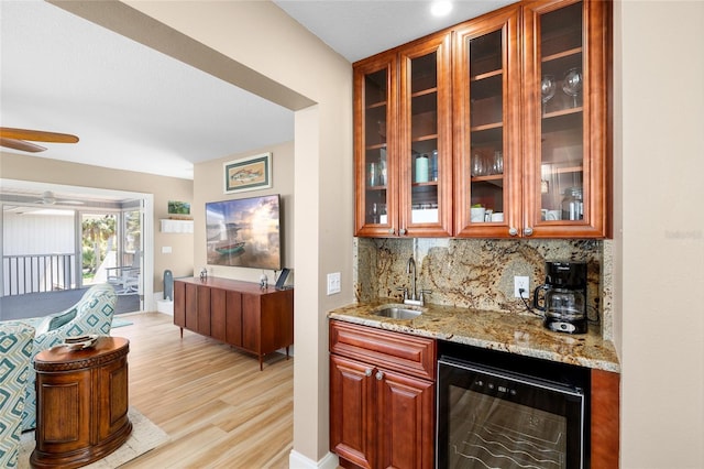 9048 Wharf Ave, Placida, FL 33946 - bar with light wood-style flooring, wet bar, a sink, wine cooler, and backsplash