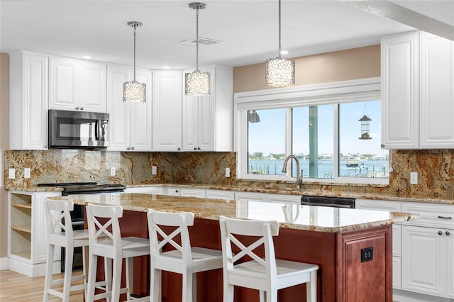 9048 Wharf Ave, Placida, FL 33946 - kitchen featuring stainless steel microwave, dishwashing machine, a center island, and a wealth of natural light