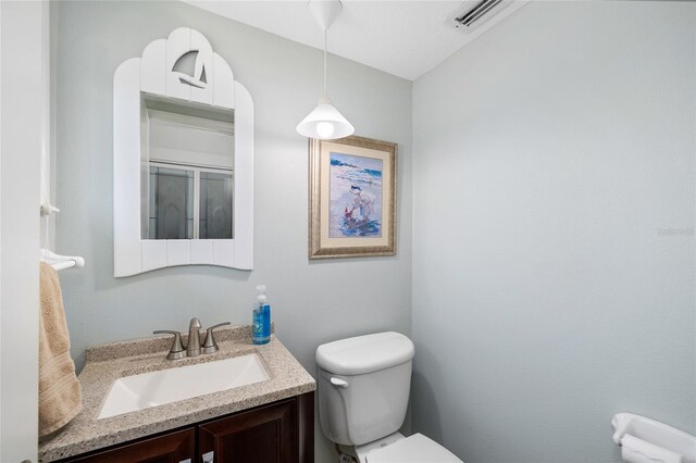 9048 Wharf Ave, Placida, FL 33946 - bathroom featuring vanity, visible vents, and toilet