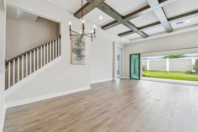 unfurnished living room with baseboards, a chandelier, beam ceiling, coffered ceiling, and wood finished floors