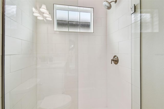 full bath featuring tiled shower and a notable chandelier