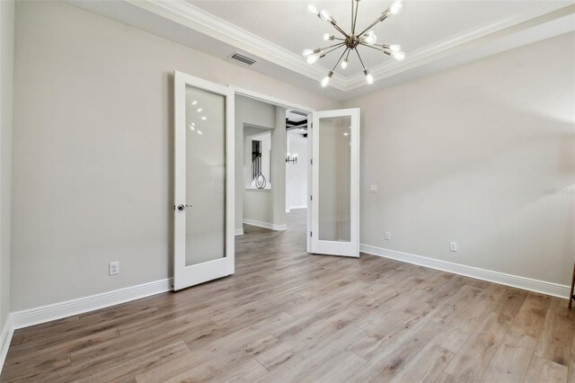 unfurnished bedroom featuring visible vents, a notable chandelier, crown molding, wood finished floors, and french doors
