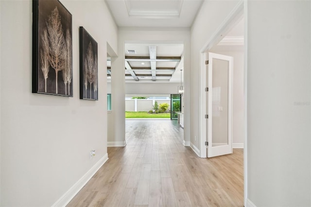 corridor featuring light wood-style flooring, visible vents, coffered ceiling, baseboards, and beam ceiling