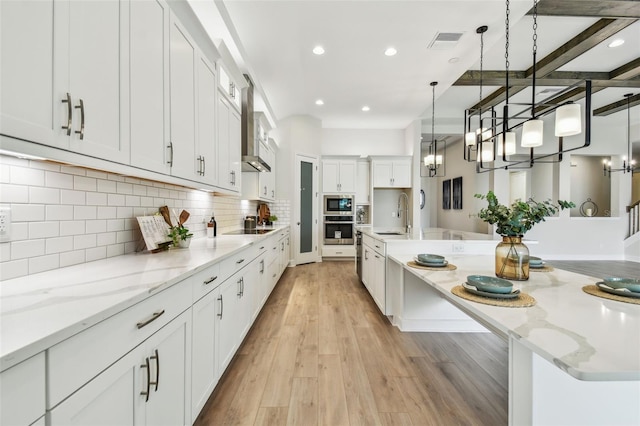 kitchen featuring visible vents, a chandelier, stainless steel microwave, a sink, and black electric stovetop