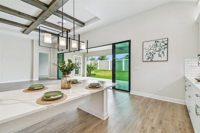 dining space with visible vents, coffered ceiling, light wood finished floors, baseboards, and beam ceiling