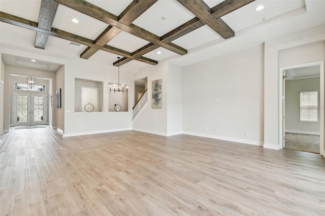 unfurnished living room with a chandelier, a healthy amount of sunlight, light wood finished floors, and coffered ceiling