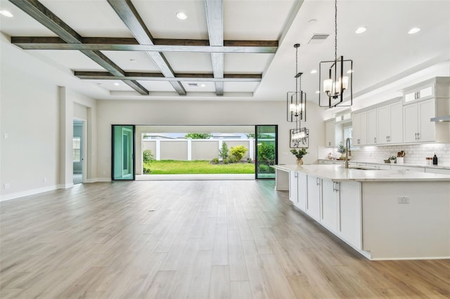 kitchen featuring an inviting chandelier, white cabinets, recessed lighting, open floor plan, and coffered ceiling