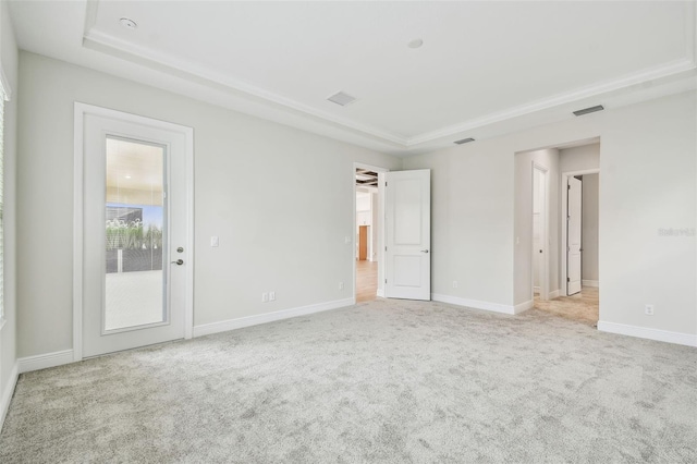interior space featuring baseboards, a raised ceiling, and light colored carpet