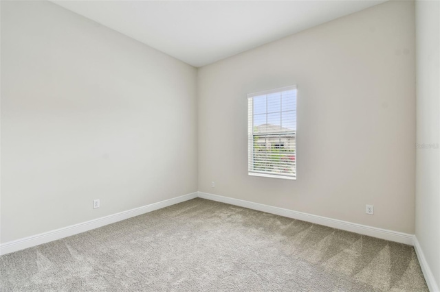 carpeted empty room with baseboards