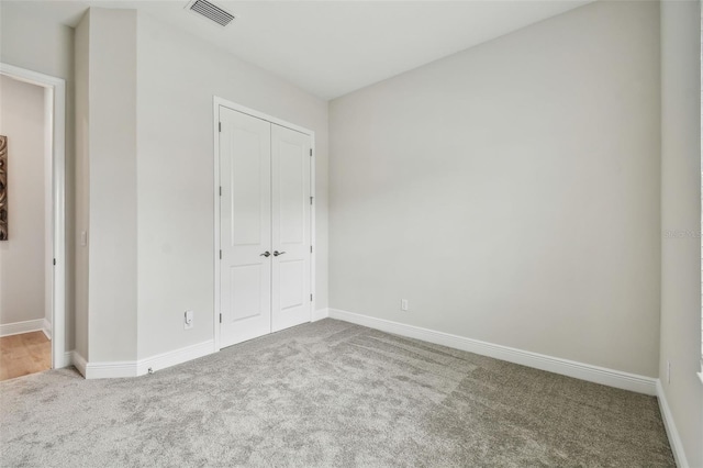 unfurnished bedroom with visible vents, a closet, baseboards, and carpet floors