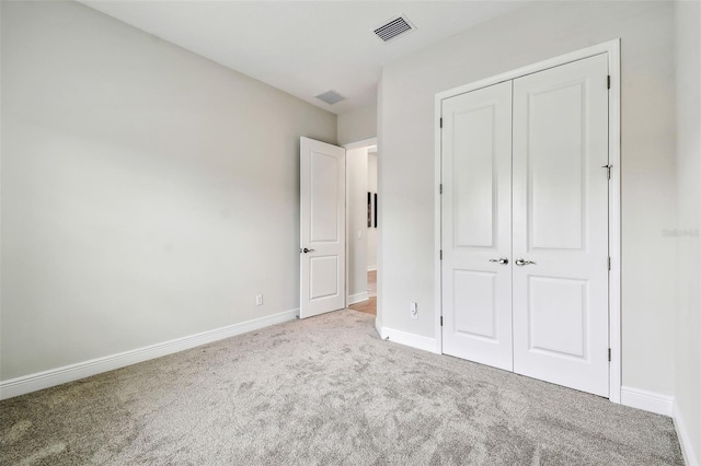 unfurnished bedroom featuring carpet flooring, visible vents, a closet, and baseboards