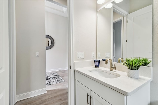 bathroom with wood finished floors, vanity, and baseboards