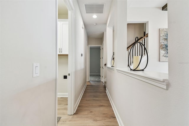 hallway featuring visible vents, light wood-style flooring, recessed lighting, and baseboards