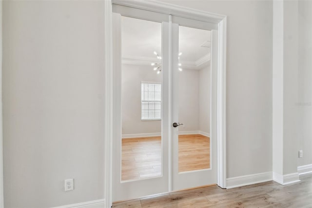 interior space with baseboards, ornamental molding, and wood finished floors