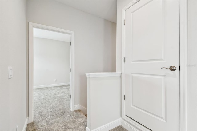 hall with baseboards and carpet