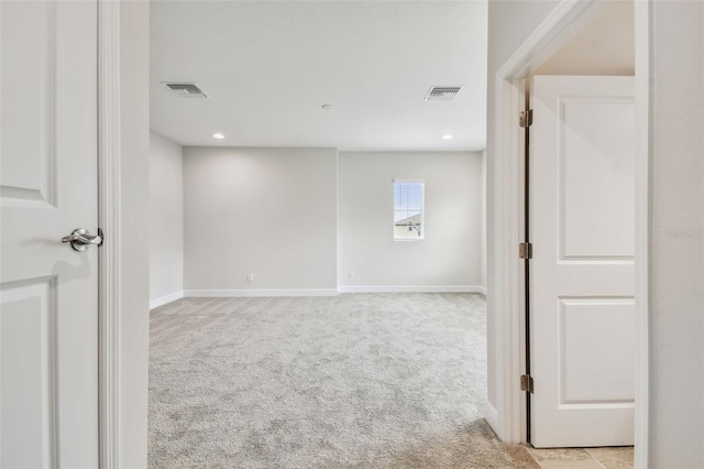 empty room with recessed lighting, visible vents, light colored carpet, and baseboards