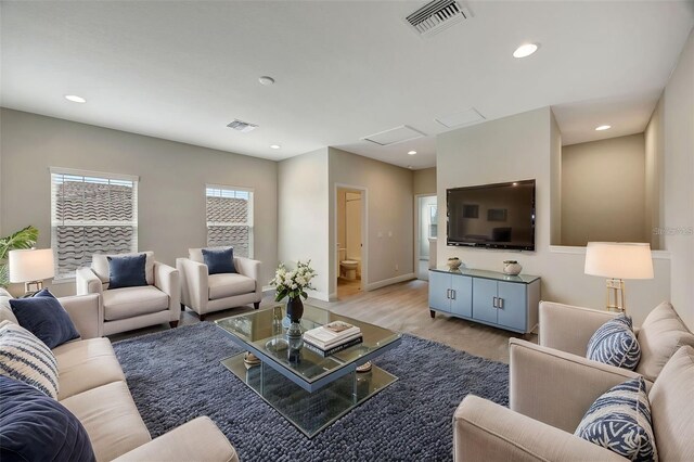 living area with wood finished floors, attic access, visible vents, and recessed lighting